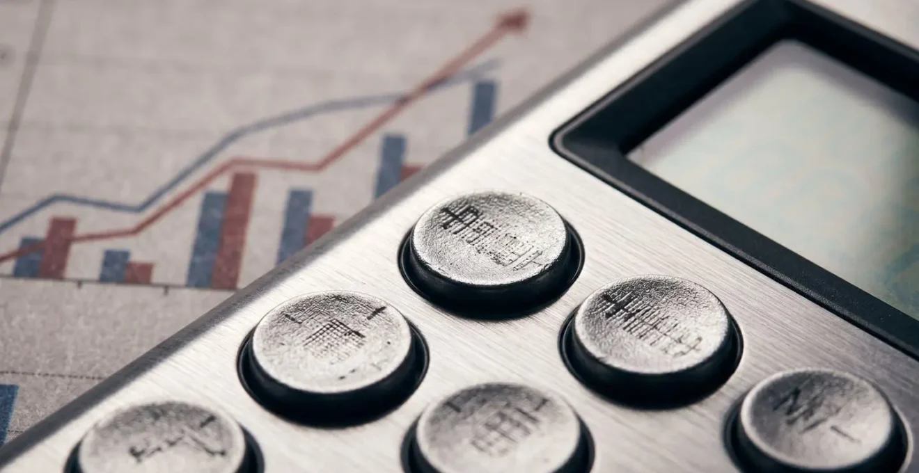 Vue macro détaillée d'une calculatrice professionnelle et de graphiques financiers illustrant le calcul du retour sur investissement